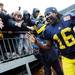 Michigan junior quarterback Denard Robinson smiles as he high-fives fans as he makes his way to the tunnel after Michigan beat Nebraska 45-17 on Saturday. Melanie Maxwell I AnnArbor.com